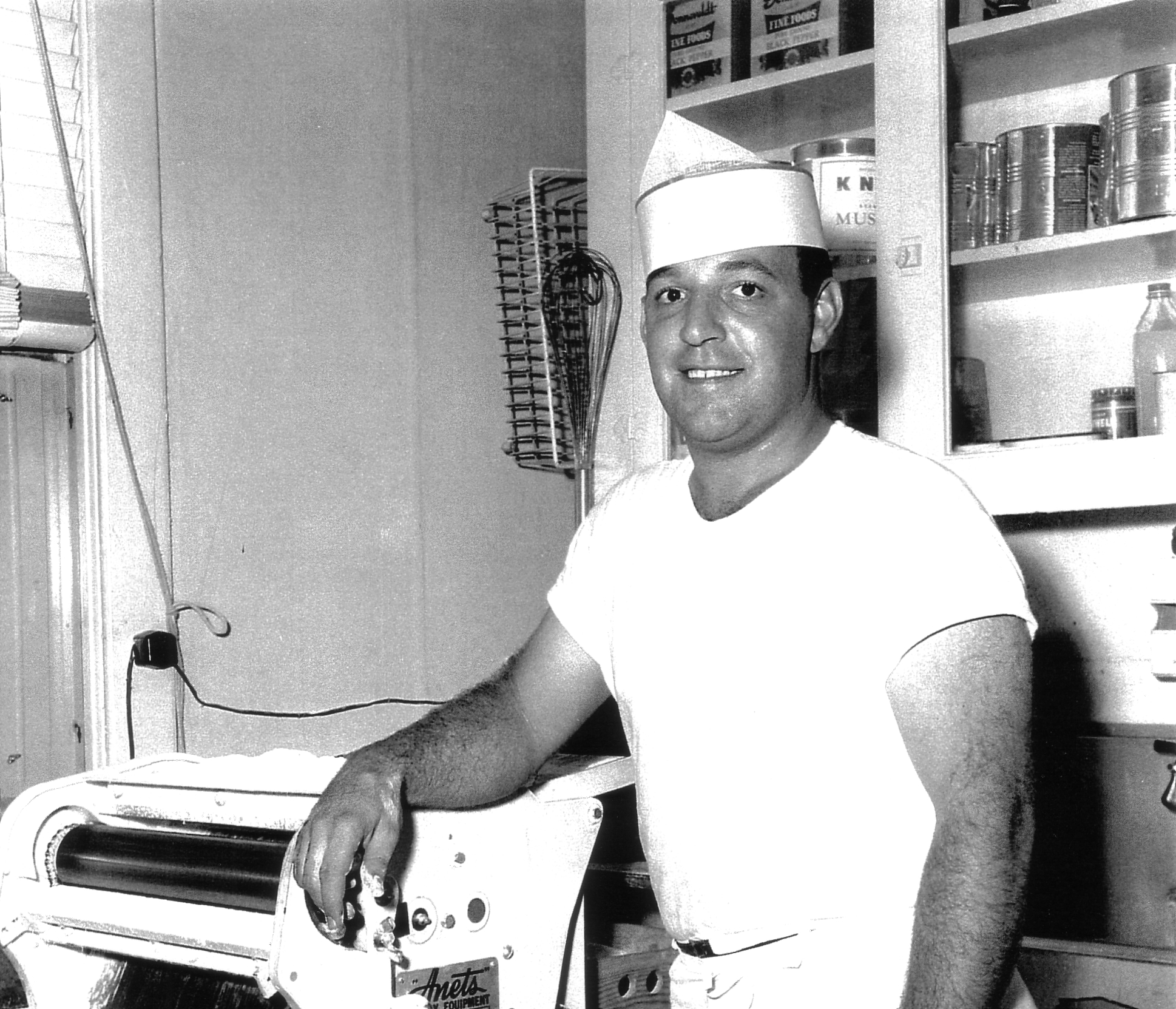 Gus Fricano, the founder of Fricano's Pizza Tavern, pictured in the 1950's with a thin crust pizza dough maker.